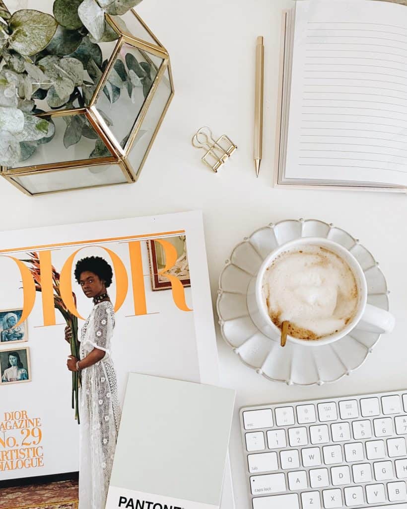 white desktop with coffee, magazine, plant, keyboard